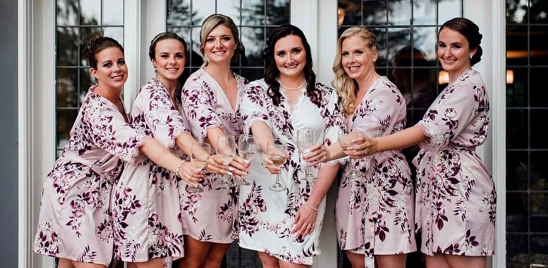 Happy bridal party posing with champagne glasses and wearing their gorgeous upswept bridal hair by Jennifer's Hair Boutique in Aurora